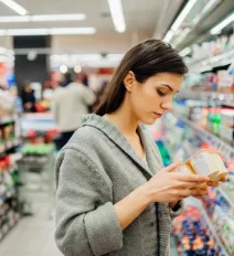 woman reading label in grocery store