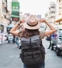 woman traveling holding hat 