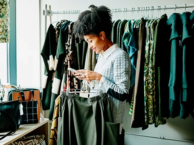 Woman shopping in retail looking at clothes teaser